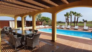 卡勒达德福斯特Villa BONITA on Golf in El Descanso ,Caleta Fuste-Fuerteventura的一个带桌椅的庭院和一个游泳池