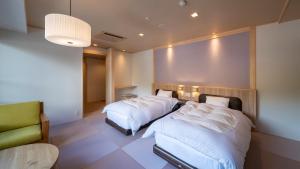 上田市中松屋传统日式旅馆的酒店客房,配有两张床和椅子