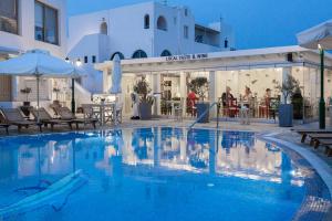 阿克罗蒂里玛索斯酒店的一个带桌子和遮阳伞的酒店游泳池