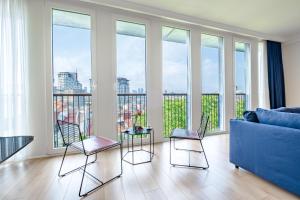 伊斯坦布尔Homie Suites - Luxury Apartments in Maçka的客厅配有蓝色的沙发和椅子
