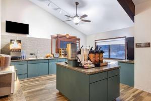 德卢斯AmericInn by Wyndham Duluth South Proctor Black Woods Event Ctr的一间设有蓝色橱柜和天花板的大厨房