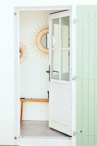 雷岛圣玛丽Maison 3 chambres plus 1 studio indépendant的一道白色的门,通向一个墙上有阳光的房间