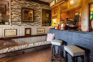 马诺比尔Castlemead Country House By The Sea的一间酒吧,里面设有两张凳子和一张长凳