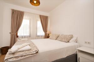 锡德海滨居所酒店的白色的卧室设有白色大床和窗户