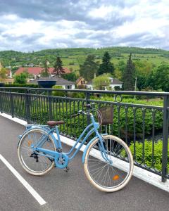 米齐格Hôtel L'Ours De Mutzig的一辆蓝色的自行车停在围栏旁边