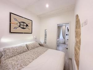 阿尔盖罗Protea House的一间白色卧室,配有一张床和一个冲浪板