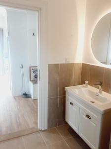 锡德海滨居所酒店的浴室设有白色水槽和镜子