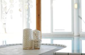 滨湖波德斯多夫Seewirt & Haus Attila的桌子上坐着三个白花瓶