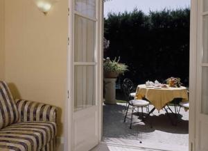 坎诺比奥Hotel Villa Delle Palme的通往带桌子和桌椅的天井的门
