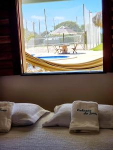 福廷Cabanas da Sorte的一张带泳池景窗户的床