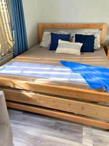 达累斯萨拉姆Kivulini House - close to the beach的卧室内的一张带蓝色枕头的木床