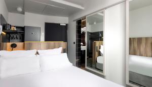 巴黎奥特利兹里贝特花园酒店的卧室配有白色的床和镜子