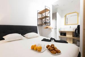 圣特罗佩Villa Sibille - Plein centre de Saint-Tropez的一张带甜甜圈和橙汁托盘的床