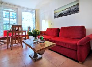 巴贝Haus Meeresblick - Ferienwohnung Strandnah A 1.07 (Ref. 128675)的客厅配有红色的沙发和桌子