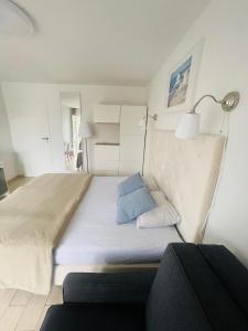 尤斯托尼莫斯基Pokoje Gościnne i Apartamenty Ula的卧室配有一张白色大床和蓝色枕头