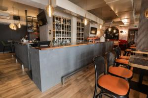 奥西耶克Sobe Merlon的餐厅内的酒吧配有木桌和椅子