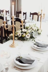 巴拉通马里亚弗都Arkánum Hotel的一张带蜡烛和白色花朵的白色桌子
