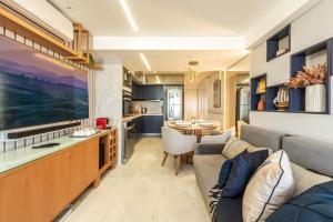 纳塔尔DELUX PRAIA Flats的客厅以及带沙发和桌子的厨房。