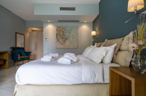 尼亚普拉莫斯Edem Luxury Apartments的卧室配有带毛巾的大型白色床