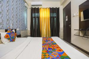 阿拉哈巴德FabHotel Royal Stay Inn的一间卧室配有一张带五颜六色棉被的床