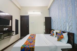 阿拉哈巴德FabHotel Royal Stay Inn的一间带大床和电视的卧室