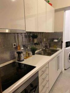 阿马多拉An elegant & cozy apartment的白色的厨房配有水槽和洗碗机
