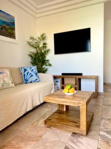 阿德耶Cosy, new studio in Costa Adeje的客厅配有沙发和带一碗水果的桌子