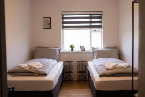 ÞingeyjarsveitGuesthouse Helluland的带窗户的客房内的两张床