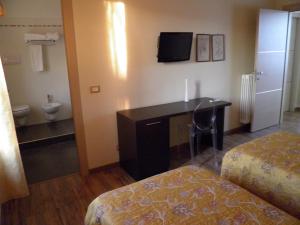 CornaletoAffittacamere Il Persicone的酒店客房设有一张桌子、一张床和一间浴室。