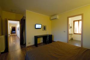 CornaletoAffittacamere Il Persicone的一间卧室配有一张床,墙上配有电视