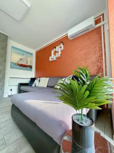 里耶卡Luxury Apartman ASIA Rijeka的一间卧室,配有一张床和一张桌子上的植物