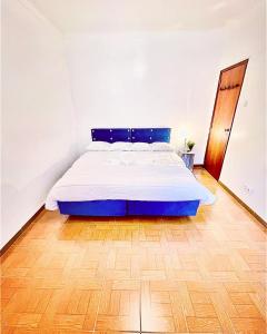 里斯本Residencial First One的铺有木地板的白色客房的一张床位