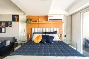 纳塔尔DELUX PRAIA Flats的一间卧室配有一张带蓝色和黄色枕头的大床
