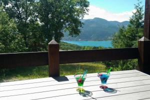 Le Sauze-du-lacLa Palatriere的木桌上的两杯玻璃,享有湖景