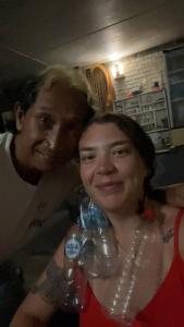 罗威那阿波罗旅舍的站在一个拿着水瓶的男人旁边的妇女