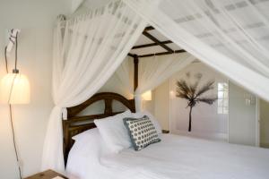 圣彼得教区小古德港酒店的卧室配有白色床和白色窗帘