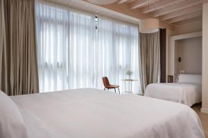 帕拉斯德丽Hotel Trina 20的酒店客房设有两张床和窗户。