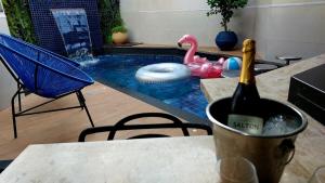 里贝朗普雷托MOTEL COPACABANA的游泳池畔的桌子上坐着一瓶葡萄酒
