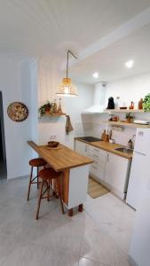 夫塞塔Ria Mar Fuzeta Apartments的厨房配有白色橱柜和木桌