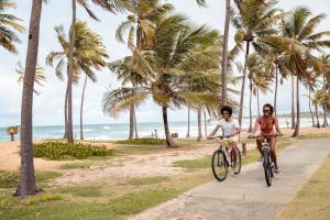 科斯塔萨乌佩Sauipe Grand Premium Brisa - All Inclusive的两人在海滩附近的一条小径上骑车