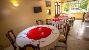 蒙巴萨Hotel Windsor-Mombasa的一间用餐室,配有两张带红色桌布的桌子