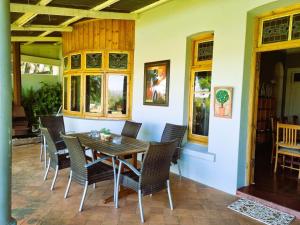 莱迪史密斯Bonnie Highlands的一间带木桌和椅子的用餐室