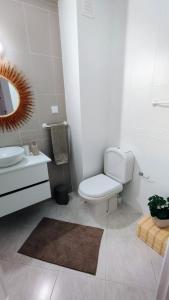 夫塞塔Ria Mar Fuzeta Apartments的白色的浴室设有卫生间和水槽。
