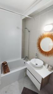 夫塞塔Ria Mar Fuzeta Apartments的一间带水槽、浴缸和镜子的浴室