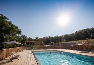 阿尔比Huttopia Pays de Cordes sur Ciel的游泳池配有椅子和遮阳伞,阳光充足