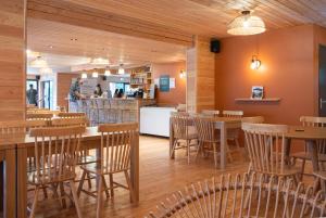 阿尔比Huttopia Pays de Cordes sur Ciel的餐厅设有木桌、椅子和柜台