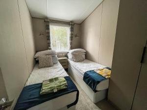 洛斯托夫特Beautiful Lodge With Decking At Azure Seas In Suffolk, Sleeps 6 Ref 32217og的小房间设有两张床和窗户