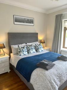 卡文Carraig House的一间卧室配有一张大床,提供蓝色的床单和枕头
