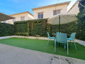曼塔Casa Vacacional en Conjunto Privado的草坪上配有一张桌子和两把椅子,并有一把伞