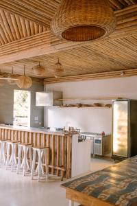 卢纳将军城Happiness Hostel Siargao的一间带木制天花板的厨房和一间带凳子的酒吧
